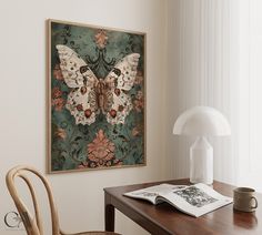 a table with a chair and a lamp on it next to a framed butterfly painting