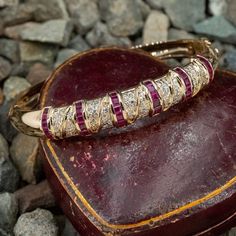 This elegant two-section bangle style bracelet is accented with thirty-six (36), channel set, square step cut natural rubies and eighty-six (86), bead set, round brilliant cut diamonds. The bracelet measures 9.5mm wide at the top, rises 5.0mm above the wrist, tapering to 5.6mm wide and 2.3mm thick at the base of the bracelet. The bracelets fits just over 6 1/2 inches. Eighty Six, Diamond Bangle Bracelet, Diamond Bangles Bracelet, Bangles Style, Step Cut, Bead Set, Diamond Bangle, Ruby Diamond, Channel Set