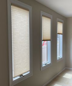 three windows with blind shades in a room