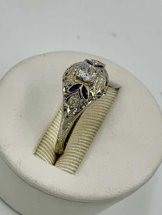 an ornate ring sits on top of a cloth