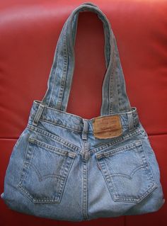 an old pair of blue jeans with a brown leather tag hanging from it's back pocket