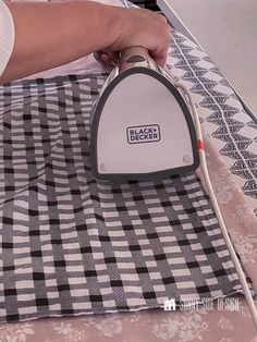 a person ironing fabric with a black and white checker pattern on the table