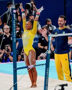 a woman standing on top of a pole in front of a crowd