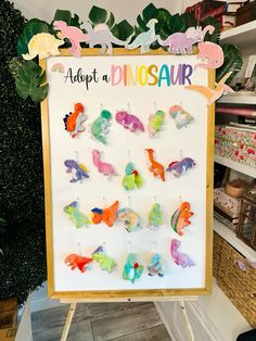 there is a sign that says adopt a dinosaur with many different colored animals on it