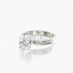 a diamond ring on a white surface with the center stone in an intricate design,