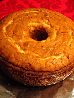 a bundt cake sitting on top of a piece of tin foil next to a red table cloth