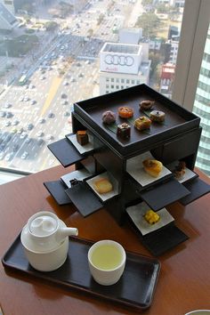 a tray with some food on top of it next to a cup and saucer