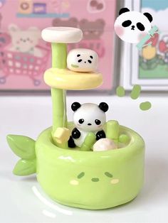 two panda bears are sitting in a green plant with white and black decorations on it