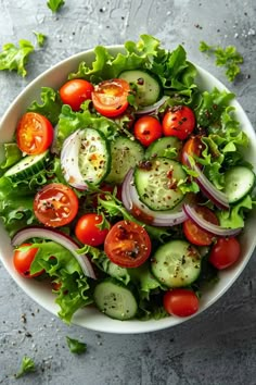 a salad with cucumbers, tomatoes and lettuce in a white bowl