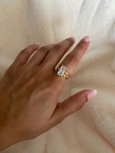 a woman's hand with a ring on it and a diamond in the middle