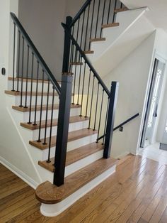 there is a stair case in the middle of this room with wood floors and white walls