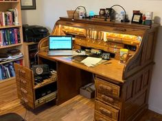 a wooden desk with a laptop on top of it next to a bookshelf