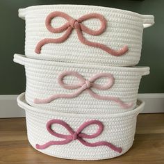 three white baskets with pink bows on them