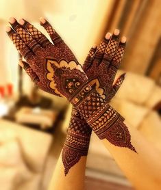 two hands with henna designs on them