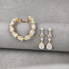 Presenting the chic Bohemian Gold Bridal Jewelry Set, a stunning combination of a teardrop crystal bracelet with its coordinating floral gold earrings, perfect for the bride's special day. The bracelet, sparkling with cubic zirconia teardrops, adds a touch of glamour to any attire, ideal for weddings, formal events, and other celebrations. It's a symbol of grace, designed to be a cherished keepsake. The Gold Crystal Bridal Earrings, with their exquisite pavé-set teardrop crystals, complement the Gold Plated Dangle Jewelry Sets For Weddings, Elegant Gold Plated Bridal Sets For Wedding, Gold Hand-set Bridal Earrings For Party, Gold Teardrop Jewelry For Wedding, Elegant Gold Drop Jewelry Set, Gold Teardrop Bracelets For Formal Occasions, Formal Gold Teardrop Bracelets, Gold Plated Drop Jewelry For Wedding, Wedding Gold Plated Drop Jewelry