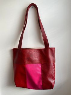 Unique handmade faux-leather tote bag in red and pink.  Bag measures 15 inches wide x 16 inches tall Total height including strap is 28 inches Cotton lining. Features two interior pockets Burgundy Rectangular Bag With Handles, Red Hobo Bag For Shopping, Red Hobo Shoulder Bag For Shopping, Red Square Satchel For Daily Use, Burgundy Rectangular Satchel For Shopping, Red Rectangular Bucket Bag For Travel, Red Rectangular Hobo Bag For Travel, Red Square Bag For Daily Use, Red Hobo Tote Bag For Daily Use