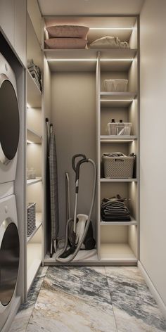 an empty washer and dryer in a closet with clothes on the shelves,