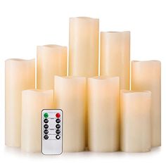 a group of candles with remote controls in front of each one on a white background