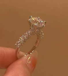 a person holding a diamond ring in their hand