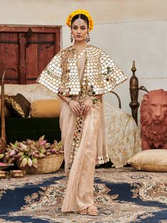 A sophisticated ensemble, this beige sari features a stunning mirror work border that adds an elegant touch. Styled with a full mirror work cape, this outfit beautifully merges traditional charm with modern glamour, making it a perfect choice for special occasions and celebrations. Cape Sleeves Saree With Resham Embroidery For Eid, Eid Saree With Resham Embroidery And Cape Sleeves, Anarkali Pre-draped Saree With Sheer Dupatta And Cape Sleeves, Navratri Dupatta With Cutdana And Cape Sleeves, Cape Sleeve Blouse With Dupatta For Diwali, Festive Eid Pre-draped Saree With Mirror Work, Traditional Sharara With Dabka Work And Cape Sleeves, Traditional Sharara With Gota Work And Cape Sleeves, Traditional Wear With Dupatta And Cape Sleeves For Festivals