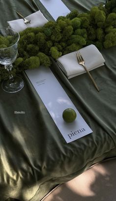 the table is set with moss and place settings