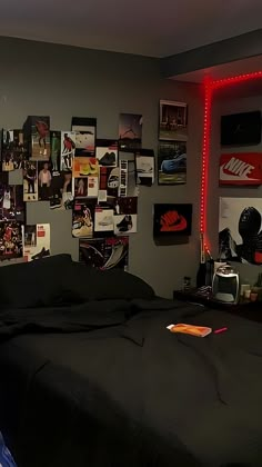 a bedroom with posters on the wall and a bed in front of an illuminated headboard