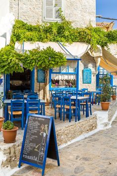 an outdoor restaurant with blue tables and chairs