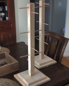 a tall wooden sculpture sitting on top of a table next to a box and chair