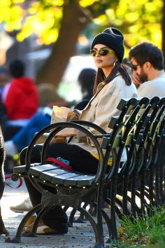 a woman sitting on top of a bench next to a dog