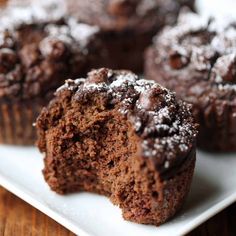 chocolate muffins on a white plate with powdered sugar