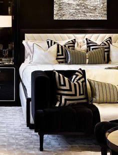 a bed with black and white pillows on it