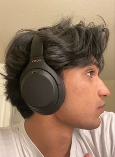 a man with black hair wearing sony headphones