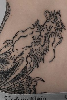 the back of a woman's stomach with a lion tattoo design on her left side