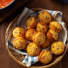 a basket filled with muffins sitting on top of a wooden table