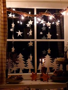 the window is decorated with christmas lights and stars on it's windowsills