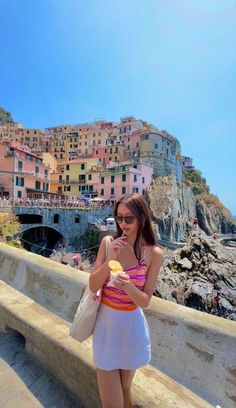 a woman standing on a bridge eating an ice cream