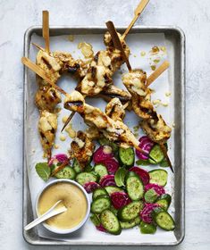 grilled chicken skewers with cucumbers, radishes and sauce