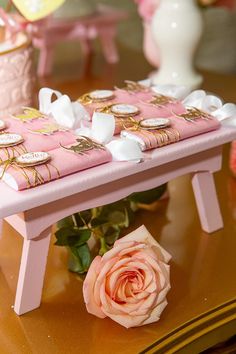 a pink table topped with plates and flowers