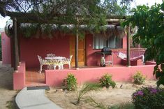 a small pink house with a patio and table