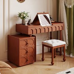 a wooden desk with a mirror and stool in front of it, next to a window