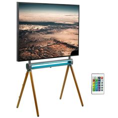 an easel with a television on it and remotes next to it, in front of a white background