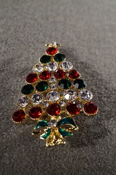 I am offering you this spectacular unique vintage gold tone bold 3 inches by 2 inch rhinestone Christmas tree pin brooch this pin has decorated with several completely covered beautiful round shaped multi colored, emerald green, ruby red, and clear white colored rhinestones, of this amazing Christmas tree pin brooch. Buyer pays all shipping and handling. Gold Christmas Brooches For Festive Occasion, Gold Holiday Brooch Jewelry, Gold Christmas Gift Pins, Gold Christmas Pins For Gifts, Gold Christmas Holiday Brooch, Gold Brooches For Christmas Gift, Brooch Christmas Tree, Christmas Bling, Gold Band Ring