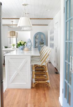 a white kitchen with blue and gold accents on the countertop, along with an island in the middle