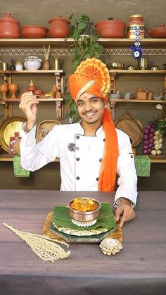 a man wearing an orange turban and holding a plate with food on it