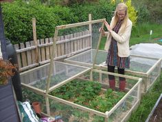 a woman standing next to a small garden