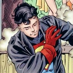 a young man wearing a superman costume and holding his arm out in front of him