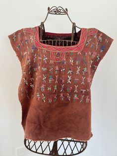 Beautiful handmade, hand-sewn, and hand-embroidered poncho-style top from Guatemala. Made by indigenous people, each blouse is unique and filled with the personal touch of the person who made it. It is a wearable work of art full of cultural history and skill. This shirt has a one-of-a-kind vibrant design with traditional patterns and incredible details on the front, back, and shoulders.  The sides are not sewn together, so it fits over the head and shoulders like a poncho. This is a unisex shirt that is between sizes . However, it really just depends on how you want it to lay and cover your body. Essentially, it's one-size fits all. It's light, comfortable, soft, and perfect for layering. It can also be worn on its own and is perfect for any time of day. Bohemian Tops With Traditional Patterns For Summer, Short Sleeve Tops With Natural Dye For Festival, Festival Short Sleeve Tops With Natural Dye, Natural Dye Short Sleeve Tops For Festivals, Traditional Cotton Tops With Natural Dye, Folk Style Festival Tops With Woven Motifs, Bohemian Embroidered Brown Tops, Traditional Brown Tops For Festivals, Traditional Brown Top For Festivals