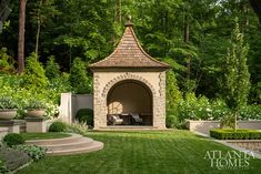 a gazebo in the middle of a lush green yard