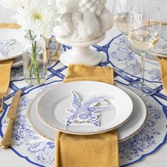 a table set with plates, napkins and wine glasses