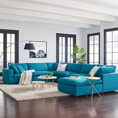 a living room with blue couches and white rugs on the wooden flooring